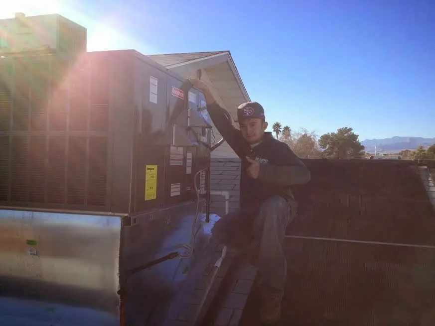 HVAC technician performing AC Tune-Up on a rooftop unit in South Cleveland